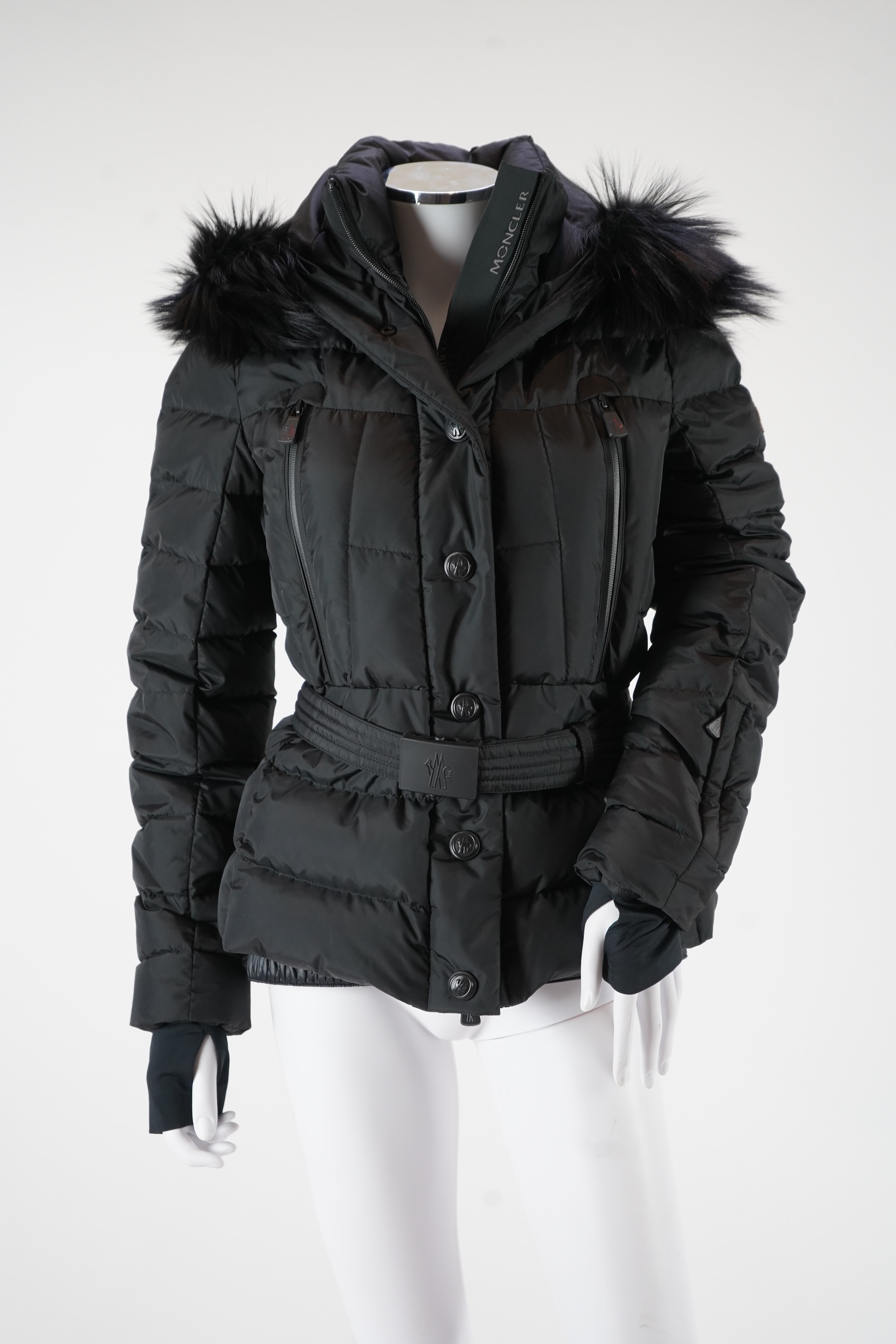 A lady's Moncler Grenoble down black ski jacket with fur trimmed hood and belted waist. UK size 10